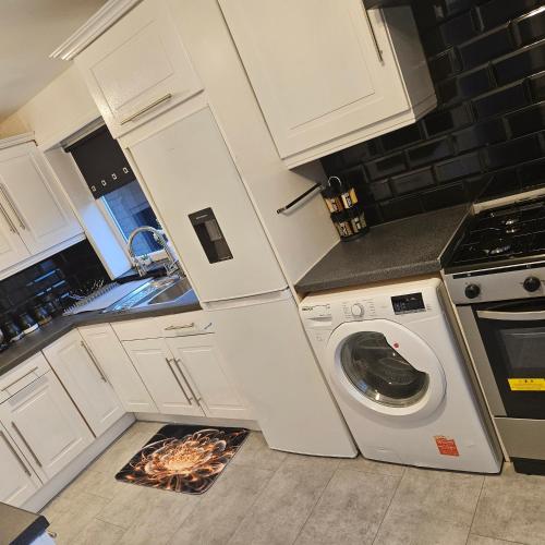 a kitchen with a washing machine and a stove at West park Royal House, Holidays, Contractors,Relocation,Free Parking & WiFi in Preston
