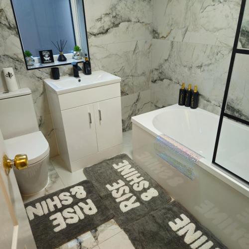a bathroom with a white tub and a toilet and a bath tub at West park Royal House, Holidays, Contractors,Relocation,Free Parking & WiFi in Preston