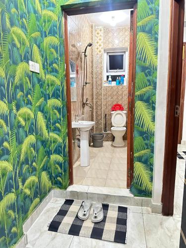 a bathroom with a toilet and a pair of shoes at Soft Greys Homes in Mombasa