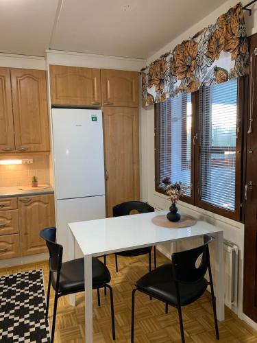 a kitchen with a table and chairs and a refrigerator at Cozy 2BR Apartment KA64 with sauna in Oulu