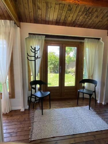 a room with two chairs and a door with windows at Jacaranda Cottage 5 min by Train or 7 min drive to Parramatta City in Wentworthville