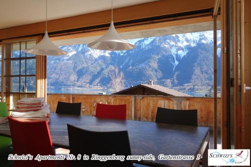 a dining room with a table and a view of a mountain at Schwizi's Apartments in Ringgenberg