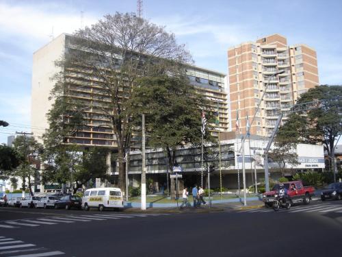 a large building on a city street with cars at Hotel Nove De Julho in Marília