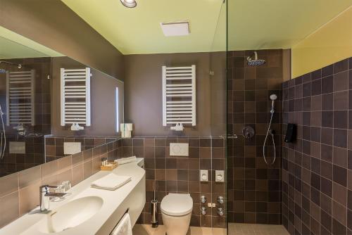 a bathroom with a toilet, sink, and mirror at The Frankfurt in Frankfurt