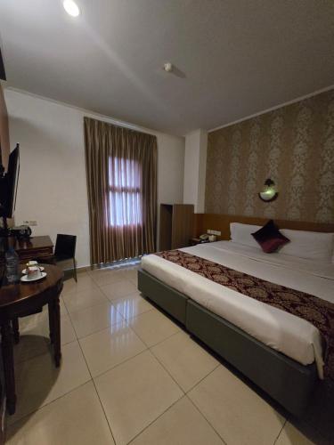 a hotel room with a large bed and a television at Marilyn Hotel Serpong in Serpong