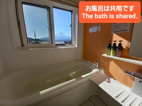 a bathroom with a bath tub and a window at Orange Cabin Inn far from station in Fujikawaguchiko