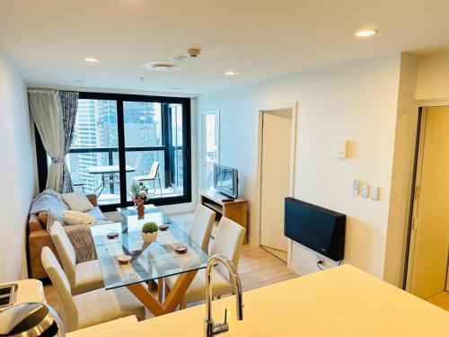 a living room with a table and a couch at Spacious Magnificent Sea Views Front of Sky Tower in Auckland
