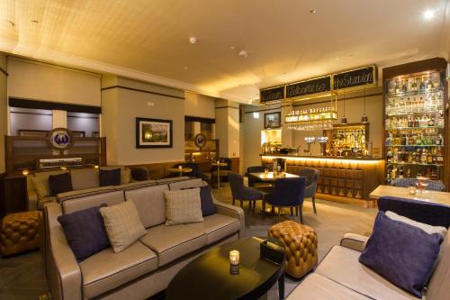a restaurant with a couch and a bar at The Station Hotel in Rothes