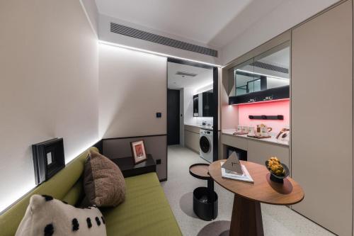 a living room with a green couch and a table at Suisse Place Beijing Jinsong Subway Station in Beijing