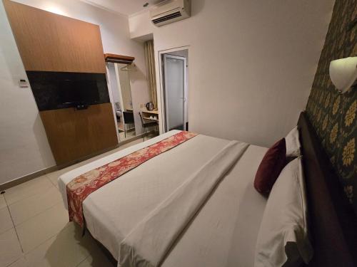 a hotel room with a large bed with a television at Marilyn Hotel Serpong in Serpong