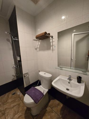 a bathroom with a toilet and a sink at Marilyn Hotel Serpong in Serpong