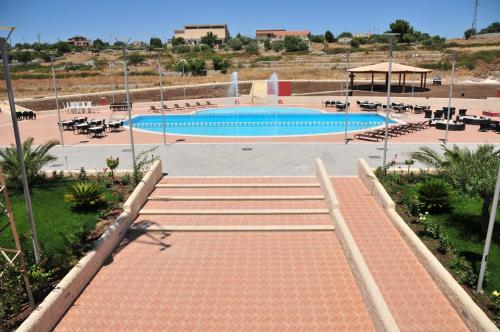 a swimming pool with a stairway leading to avisorvisor at Hotel Borgo Don Chisciotte in Modica