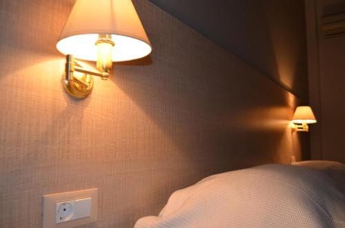 a bedroom with a bed and two lights on the wall at Archontissa in Ermoupoli