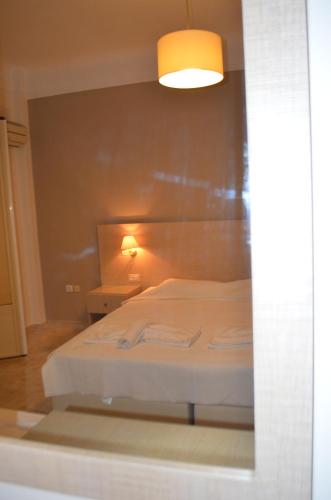 a bedroom with a white bed with a light on it at Archontissa in Ermoupoli
