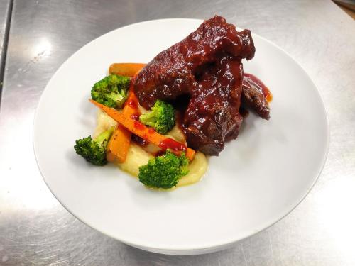 a white plate of food with meat and vegetables at Villa Isabel Hotel in Sorsogon