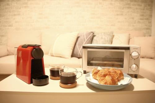 a table with a microwave and a plate of food at Casa Stella 18 by Liaison in Osaka