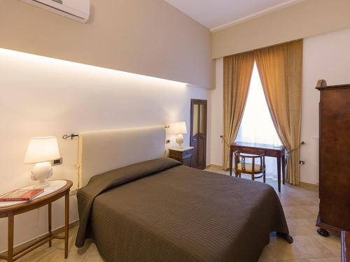 a bedroom with a bed and a table and a desk at Nonna Jole in Lecce