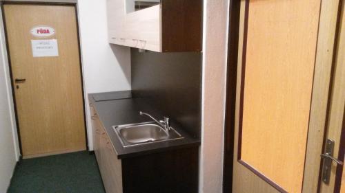 a small kitchen with a sink next to a door at Hostel Karin in Ostrava