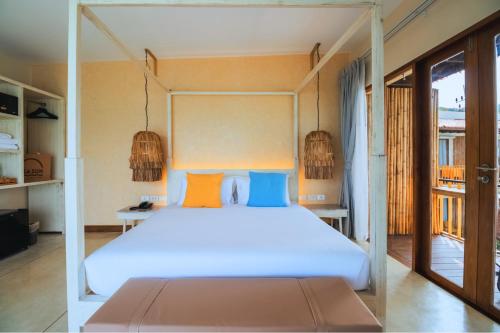 a bedroom with a large white bed with orange and blue pillows at Sea Sun Bed & Beyond in Bang Rak Beach