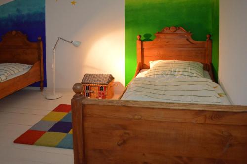 a bedroom with a wooden bed and a green wall at Himmel&Erden in Nordleda
