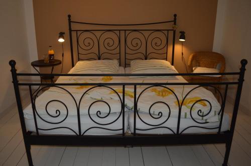 Bett mit schmiedeeisernem Rahmen und weißer Bettwäsche in der Unterkunft Himmel&Erden in Nordleda