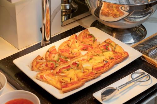 two slices of pizza on a plate on a counter at PANAMA Nha Trang Hotel in Nha Trang