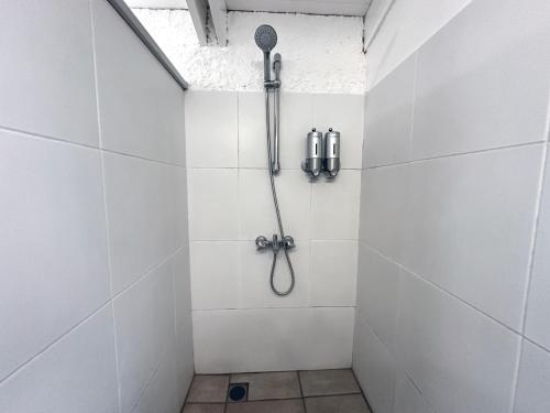 a bathroom with a shower with a shower head at Te Fiti Lodge Haapiti - Accès lagon et piscine in Hauru