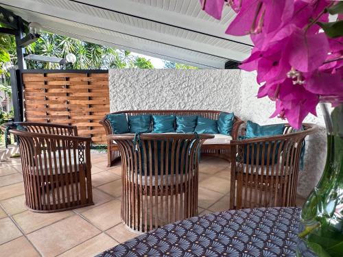 a patio with a table and chairs and a couch at Te Fiti Lodge Haapiti - Accès lagon et piscine in Hauru