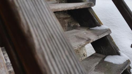 a wooden staircase covered in snow at Hotel Astoria in Ulrichen