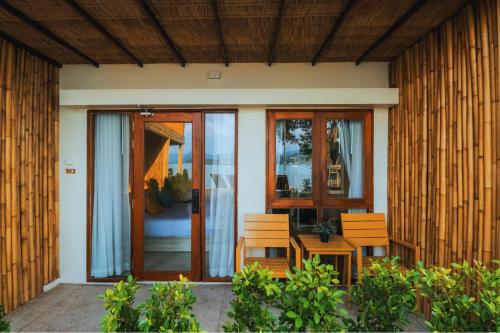 a house with two chairs and a glass door at Sea Sun Bed & Beyond in Bang Rak Beach