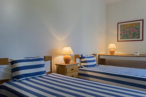 ヴィラモウラにあるAkisol Vilamoura Nature IIのベッドルーム1室(青と白のストライプのベッド2台付)