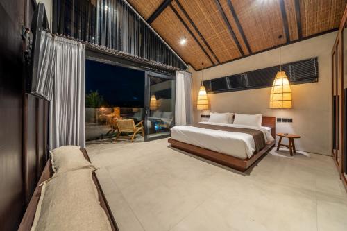Un dormitorio con una cama y una ventana grande. en Stunning Mulu A1 Brand New Private Villa in Badung - Huge Pool - Modern Luxury, en Uluwatu
