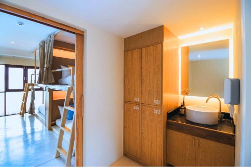 a bathroom with a sink and a bunk bed at Sea Sun Bed & Beyond in Bang Rak Beach