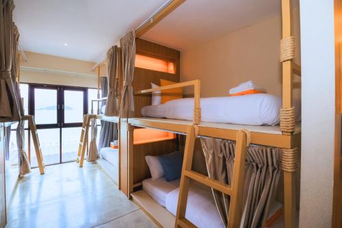 a room with three bunk beds in a room at Sea Sun Bed & Beyond in Bang Rak Beach