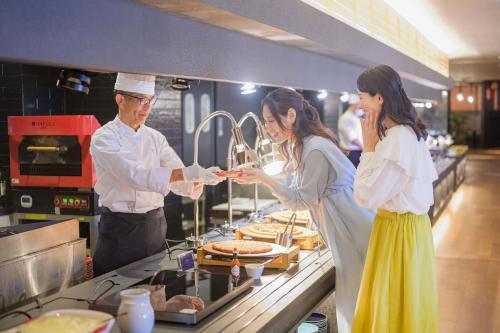 a man and woman standing in a kitchen preparing food at TAOYA Shirahama Senjyo in Shirahama