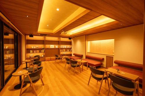 a restaurant with tables and chairs and a chalkboard at Dantokan Kikunoya in Otsu