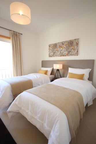 a bedroom with two beds and a painting on the wall at Josefa D’Óbidos Apartment in Casal da Lagoa Seca