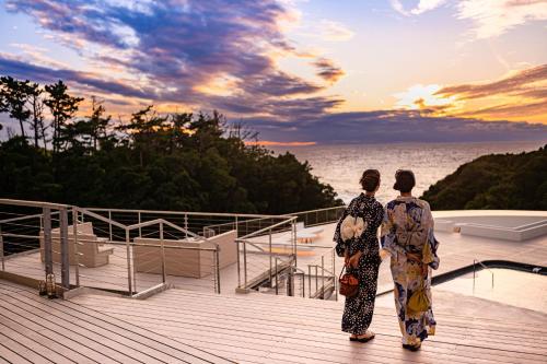 two people standing on a deck looking at the ocean at TAOYA Shirahama Senjyo in Shirahama