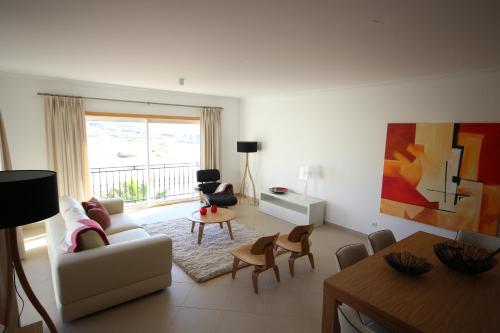 uma sala de estar com um sofá, cadeiras e uma mesa em Josefa D’Óbidos Apartment em Praia del Rei