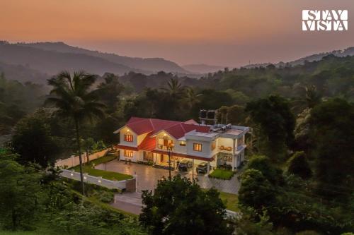 an aerial view of a house with a sunset at StayVista at Spice Notes - Breakfast Included in Munnar