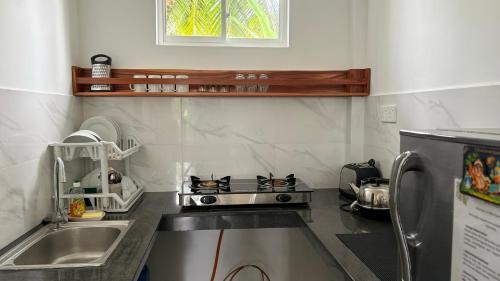 a small kitchen with a stove and a sink at Coastal Cloud in Hikkaduwa