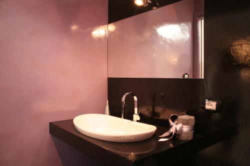 ein Badezimmer mit einem weißen Waschbecken und einem Spiegel in der Unterkunft Ca' Ottocento in Lazise