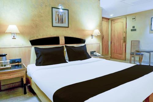 a bedroom with a large white bed and a desk at Townhouse Oak JM Road Formerly Krishna presidency in Pune