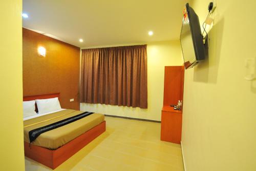 a bedroom with a bed and a flat screen tv at Gurney Inn in George Town