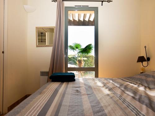 - une chambre avec un lit en face d'une fenêtre dans l'établissement Appartement au coeur du Golf de Saumane, à Saumane-de-Vaucluse