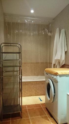 a bathroom with a washing machine and a bath tub at Apartment CasaVovo in Costa Calma