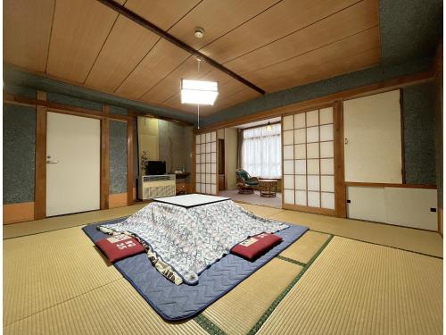 長野市にある横倉 旅館の真ん中にベッドがある部屋