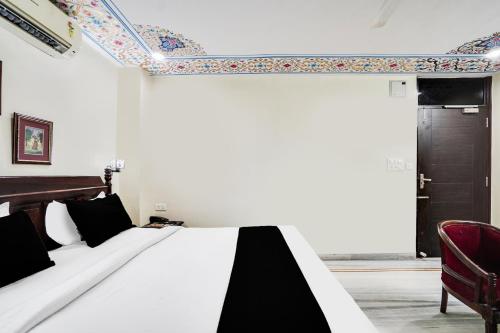 a bedroom with a bed with a black and white comforter at Super Townhouse Durgapura formerly Gumaan Heritage in Jaipur