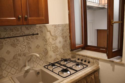 a kitchen with a stove and a sink at La Conchiglia Tra i Due Mari in Trapani