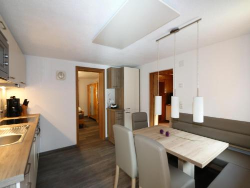 a kitchen and dining room with a wooden table and chairs at Farmhouse in Tobadill with Mountain Views in Tobadill